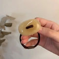 Close-up of a minimalist brown elastic hair scrunchie with an amber resin oval bead - Milk Coffee
