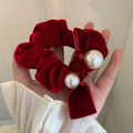 Dettaglio di un elastico per capelli in velluto rosso con fiocco e perle bianche eleganti - Borgogna