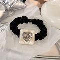 Close-up of leopard heart crystal on pleated black scrunchie with marble resin base - Shell White Heart - Scrunchie