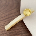 Detail van elegante crème acetaat haarklem met een goudkleurig metalen accent - Crèmewit