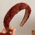 Nahaufnahme des dicken rot-orangen Tweed-Haarreifens mit gewebter Textur und Samtfutter - Vintage Goldfaden Roter Strickstil