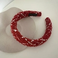 Detailed macro view of a red handmade knitted headband with white cross-stitch on a tray - Style 1 Red Headband