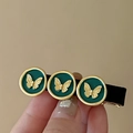 Détail de la pince à cheveux vintage avec sceaux verts et motifs de papillons dorés - Vert