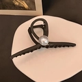 Detalle de pinza de pelo mate con perla grande sobre bandeja cerámica vintage - Café Oscuro