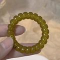 Macro shot of an olive green translucent spiral hair tie made of smooth elastic resin - Mustard Yellow