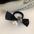 Dettaglio di un elastico per capelli con fiocco nero, perla e pietra in resina - Grigio
