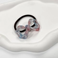Close-up of pink and blue marble pattern bow hair tie on a white decorative plate - Blue Cherry Pink