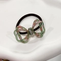 Macro view of 3D hollow bow hair tie with green and pink tortoiseshell pattern - Transparent Green Pink