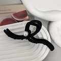 Dettaglio della molletta per capelli nera opaca con perla bianca su vassoio in ceramica - Nero opaco