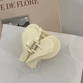 Close-up of a cream acrylic heart hair claw clip with a glossy finish and metal spring - White