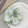Primer plano de coletero blanco con estampados florales verde claro y azul de tela - Rosa Verde
