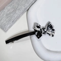 Detalle de la pinza de pelo con lazo de acetato jaspeado y grabado de France Handmade en clip - Negro & Blanco