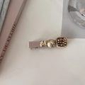 Detail of elegant hair clip with ribbon, gold butterfly, and pearls on a cream surface - Champagne Square Stone
