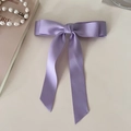 Detail view of light purple satin bow hair clip with long streamers on silk fabric - Purple