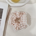 Detail of pink and white checkered scrunchie with lace trim on a lifestyle background - Light Orange