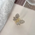 Detalle de una pinza para el pelo de mariposa dorada con brillantes diamantes de imitación - Estilo de Circonita