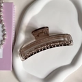 Detail view of amber resin hair claw clip on white tray with pearl necklace - 5# 10.5CM Rectangular Claw Clip