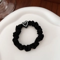 Detail of black elastic hair scrunchie with heart charm on a white ceramic tray - Black