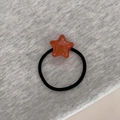 Gros plan sur l'élastique étoile en résine orange avec texte doré France Handmade et cordon noir - Orange