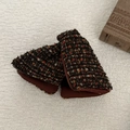 Vista dettagliata di fermagli per capelli in tweed a quadri con pompon colorati su stoffa - Pinza Triangolare Nera a Pois Rossi