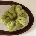 Fuzzy green plush scrunchie on a wooden tray for elegant autumn and winter hairstyles - Grass Green