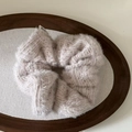 Close-up of fuzzy knit hair scrunchie in pale purple with soft plush texture on wood tray - Milk Tea