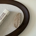 Detail showing the thick knit texture of a beige crochet teardrop hair clip on canvas - Milk Tea