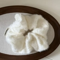 Close-up of white plush knit scrunchie with soft faux mohair texture and logo tag - White