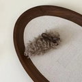 Detail of plush lamb wool hair clip with a dark brown faux leather bow on a tray - 4# Milk Tea Curly with Brown Bow