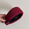 Dettaglio del cerchietto bordeaux in tessuto a coste con fodera in raso nero ed etichetta - Rosso