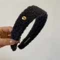 Détail du serre-tête en peluche noire avec emblème métallique doré Believe In Yourself - Bleu marine