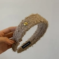 Détail d'un serre-tête en laine de mouton kaki avec bouton doré et étiquette tissée - Couleur Thé au Lait