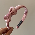 Detail eines rosa Samt-Haarreifens mit Marmormuster, Schleife und Hand-Made-Etikett - Rosa Samt Schleife Haarreif