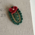 Close-up of handmade crochet Christmas tree hair clip with red bow and pearl detail - Green Wavy Oval Red Bow (2#)