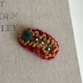 Close-up of a handmade crochet Christmas hair clip with red yarn and pearl accents - Red Pleated Turmeric Wool Clip (4#)