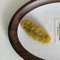 Primer plano detallado de una pinza de pelo de felpa color amarillo jengibre - Amarillo Jengibre