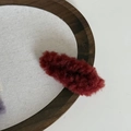 Detalle de pinza para el pelo de felpa marrón caramelo sobre madera, accesorio de invierno - Rojo