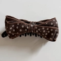 Dettaglio del fermaglio a banana marrone con fiori, doppio fiocco e denti in plastica - Molletta Banana Con Fiocco Floreale Caffè
