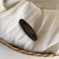 Detailed view of brown oval hair clip with matte velvet texture on a woven fabric base - 5# Brown Oval Hair Clip