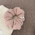 Close-up of pink knitted scrunchie with soft wool texture and a small bow label - Pink Striped Knitted Hair Tie