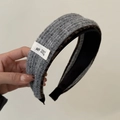 Detail view of grey knitted headband with leopard print lining and brand label - Gray Knit Headband