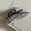 Detalle macro de una pinza para el pelo de felpa gris con un delicado lazo de cuero negro - Gris