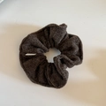 Close-up of chocolate brown wool felt scrunchie with soft matte texture and small woven label - Coffee Knit Scrunchie