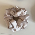 Detail of soft champagne gold satin scrunchie with pleated texture and glossy finish - Creamy White Satin