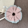 Détail d'un chouchou en tricot rayé rose et bleu clair avec bords ondulés doux - Bord Bleu Clair Chouchou Tricoté Rose