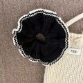 Détail d'un chouchou floral en tricot contrasté et tissu crème avec étiquette egg - Bord Blanc Chouchou Tricoté Noir