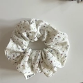 Détail du chouchou à fleurs avec texture en coton et étiquette de marque tissée - Fleur Rouge Blanc