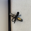Close-up of rhinestone bow hair clip with gray felt and metal tag on linen board - Dark Gray Triple Crystal Bow Style