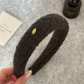Thick dark grey faux shearling headband with an oval golden metal logo detail - Black