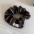 Dettaglio di scrunchie in maglia a righe marroni con etichetta Hello New York e ciondolo - Elastico per Capelli Caffè Bianco a Righe Bordo Grigio